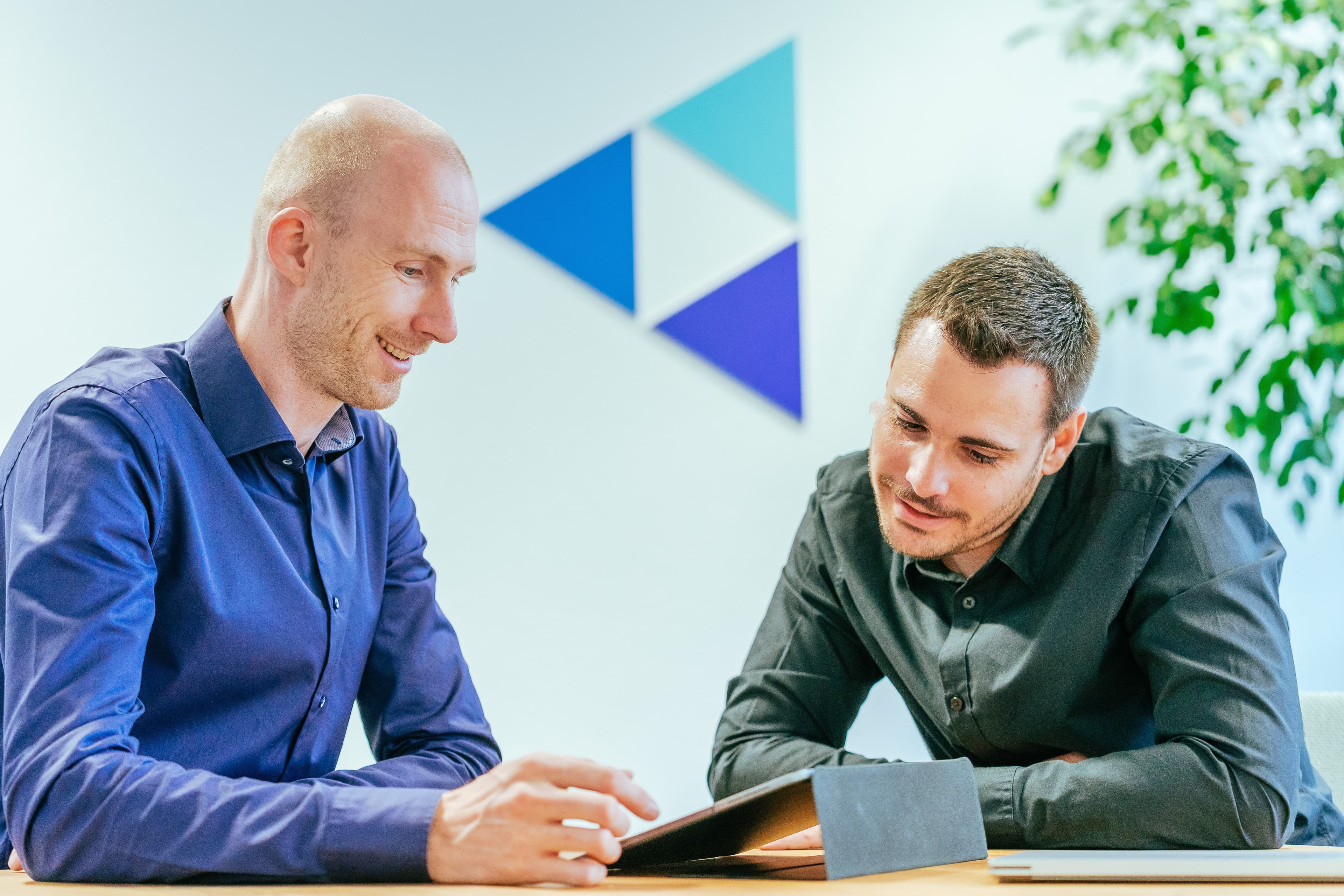 Two NMS colleagues going through content on a tablet together